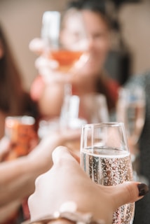 Soft-focus image of guests raising glasses in a heartfelt wedding toast.
