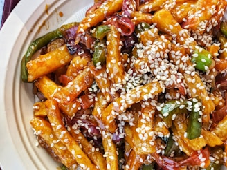 A sizzling platter of golden, crispy Seoul chicken garnished with sesame seeds and fresh herbs.