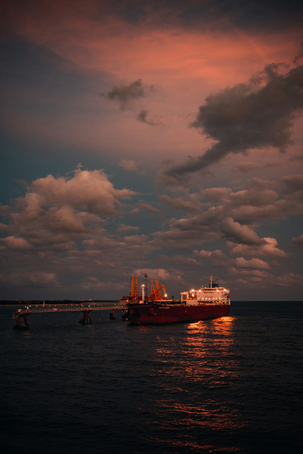 red and white ship on sea under cloudy sky during daytime