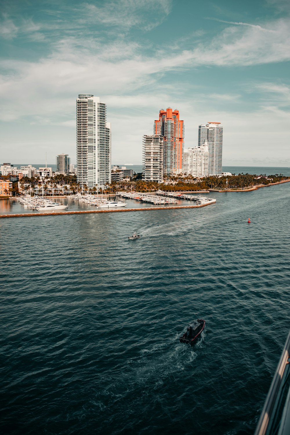 white and black boat on sea near city buildings during daytime