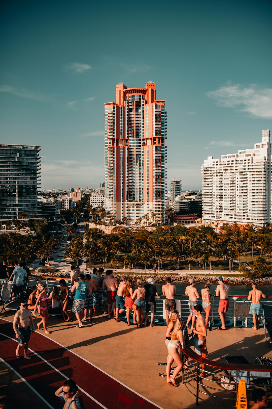 people sitting on brown wooden bench near high rise buildings during daytime