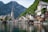 houses near body of water and mountain during daytime