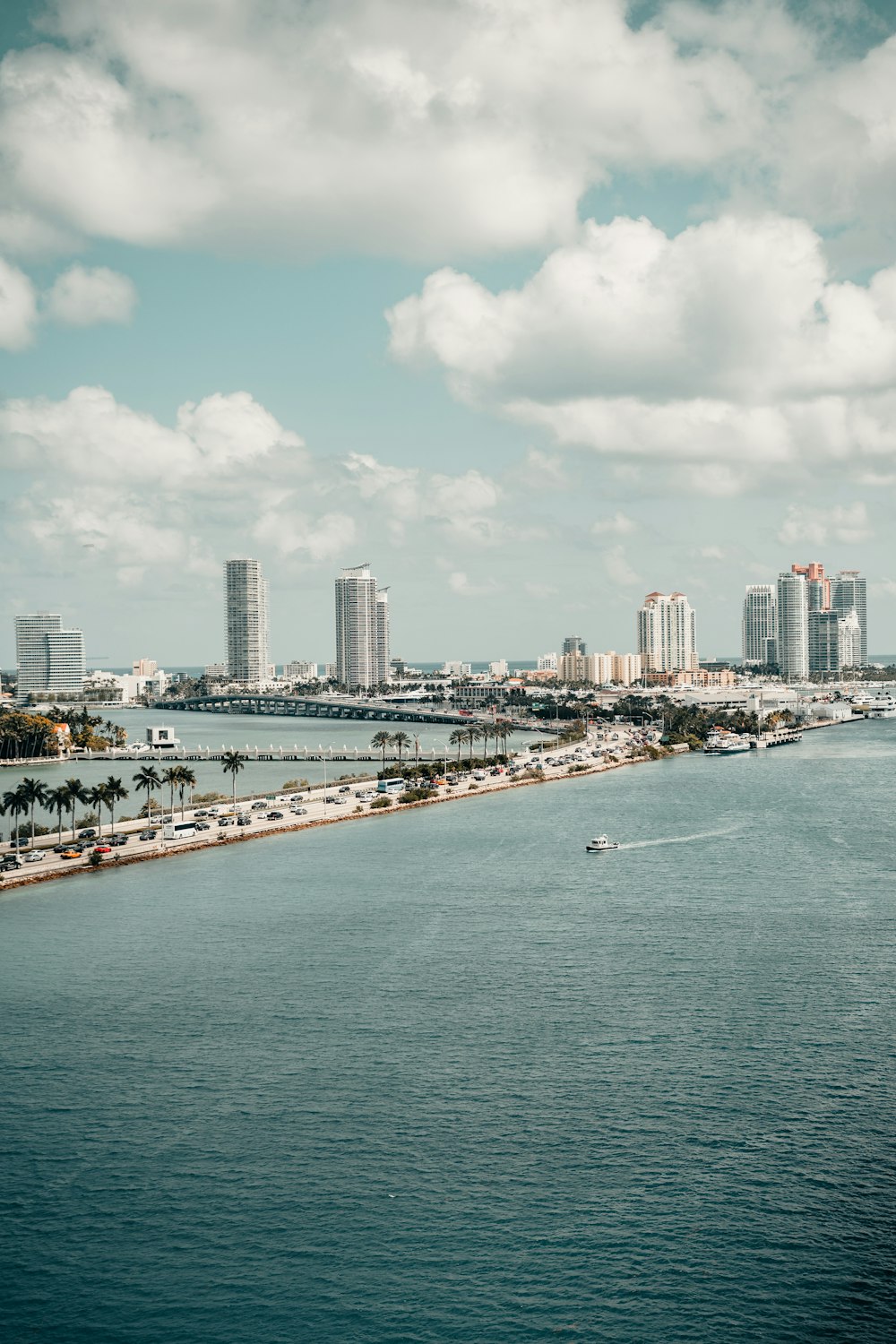 city skyline under white clouds and blue sky during daytime