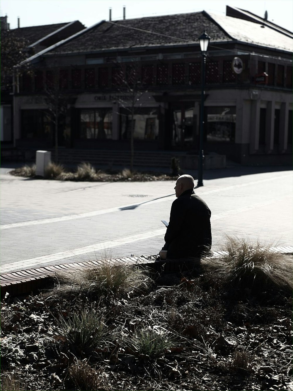 homem em jaqueta preta andando na calçada durante o dia