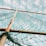 A net is stretched between rusty metal poles with a sky filled with clouds in the background. The net appears tangled at the bottom and is colored green.