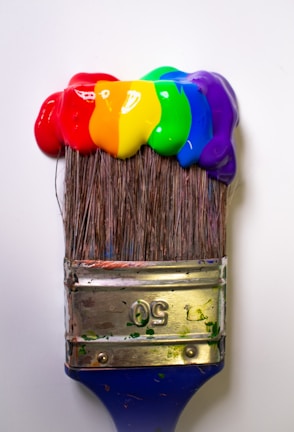Minimalist shot of paintbrushes dipped in vibrant red paint against a simple backdrop