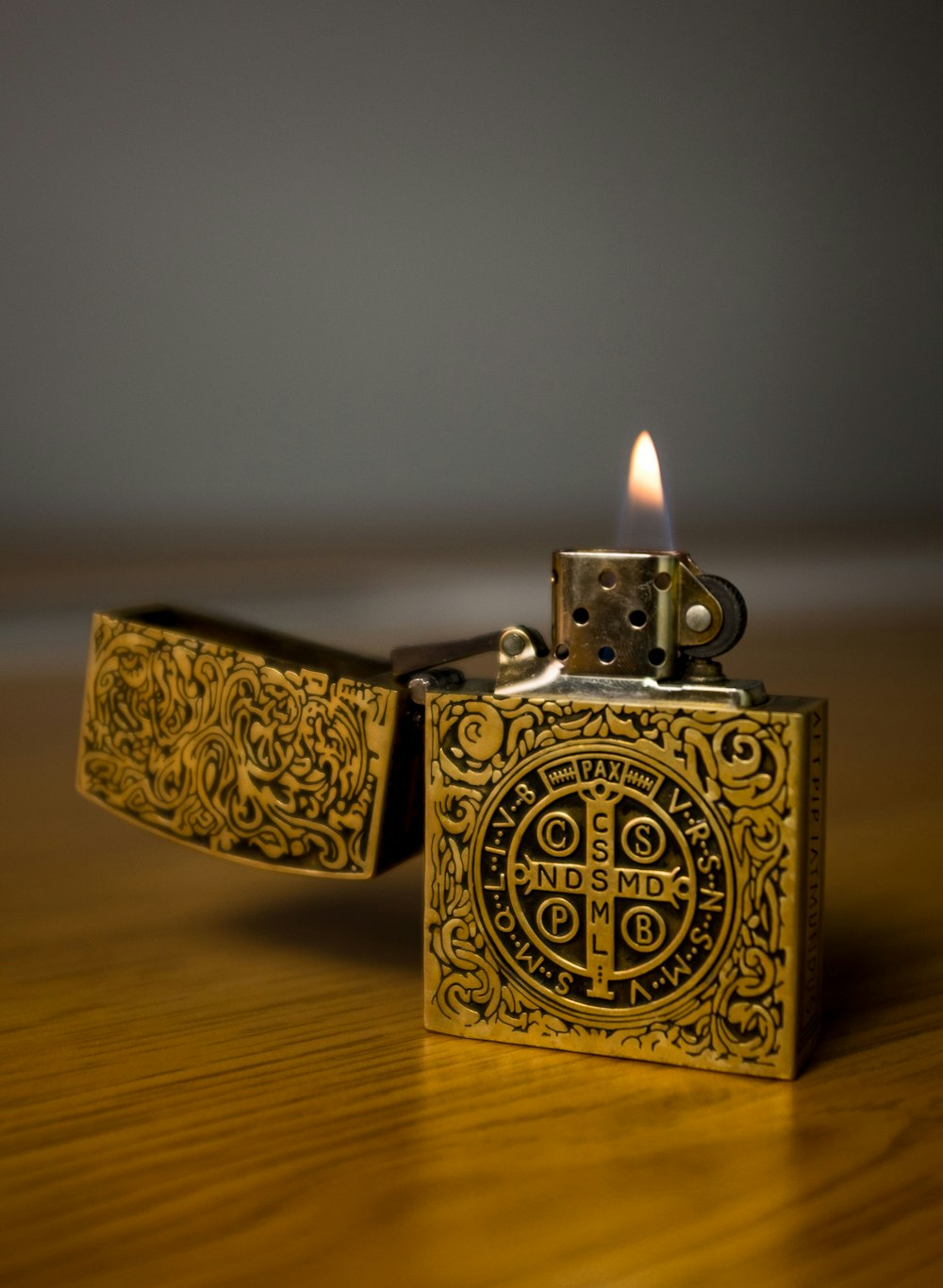 gold flip lighter on brown wooden table