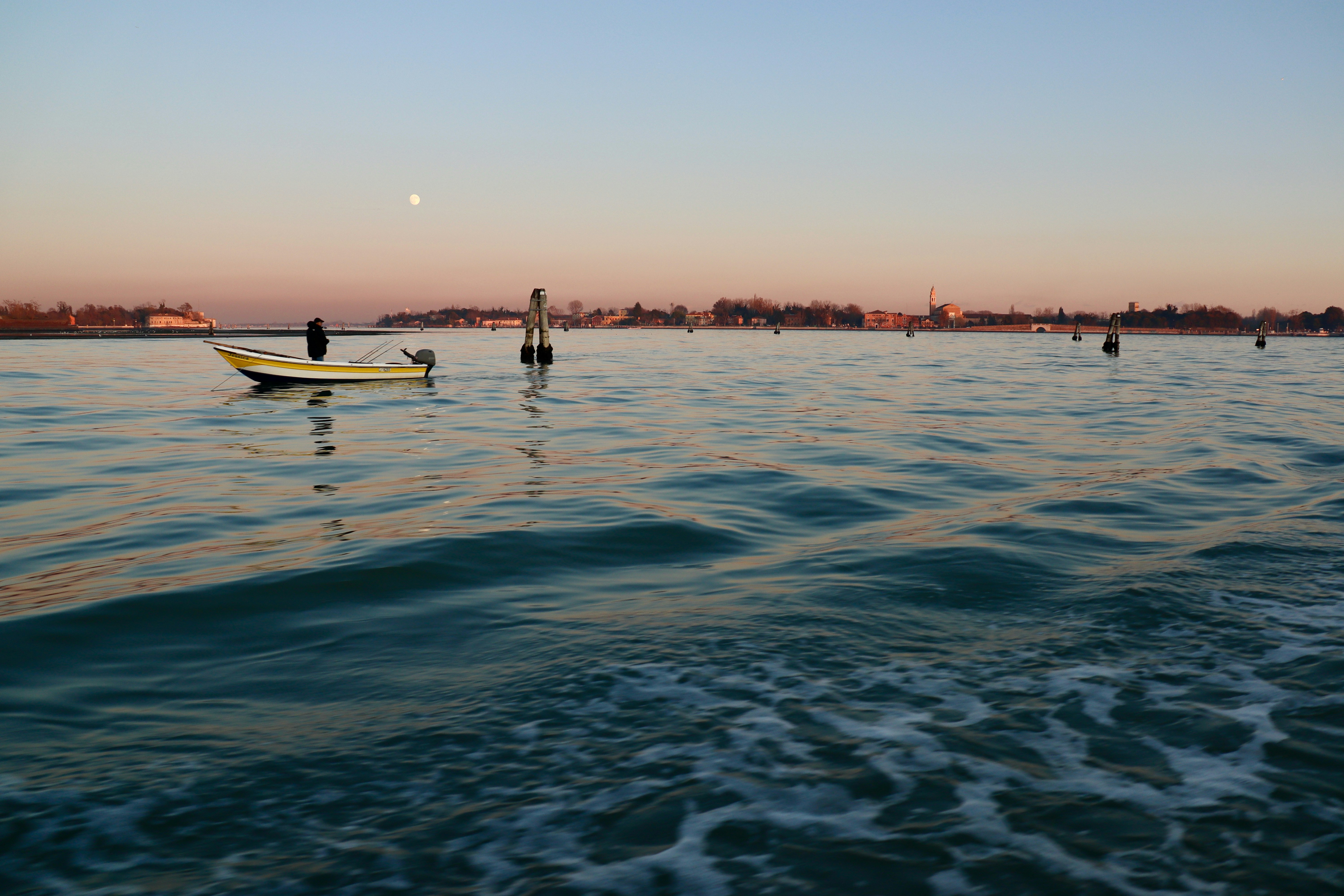 silhouette of people on white boat on sea during sunset