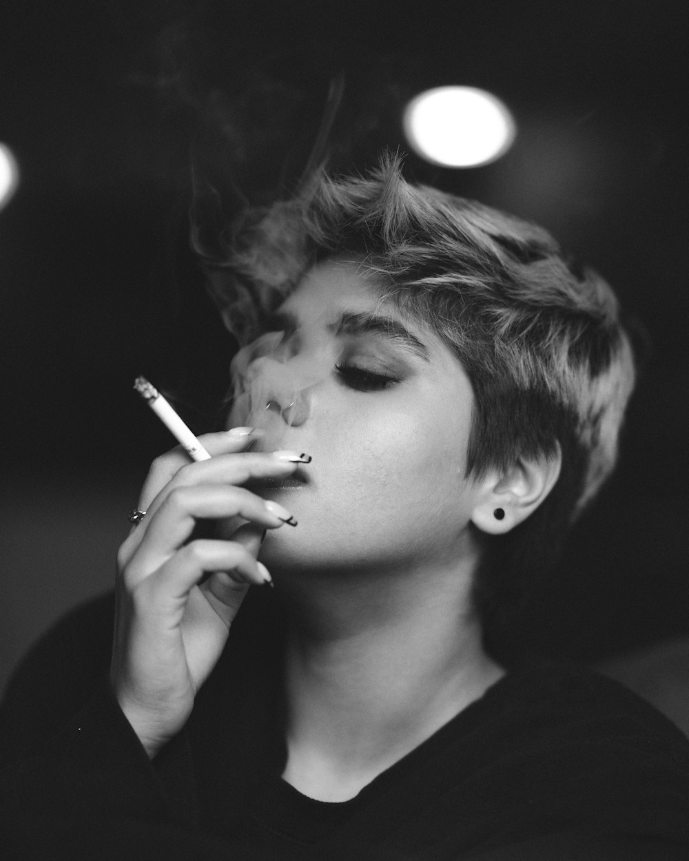 grayscale photo of woman smoking cigarette