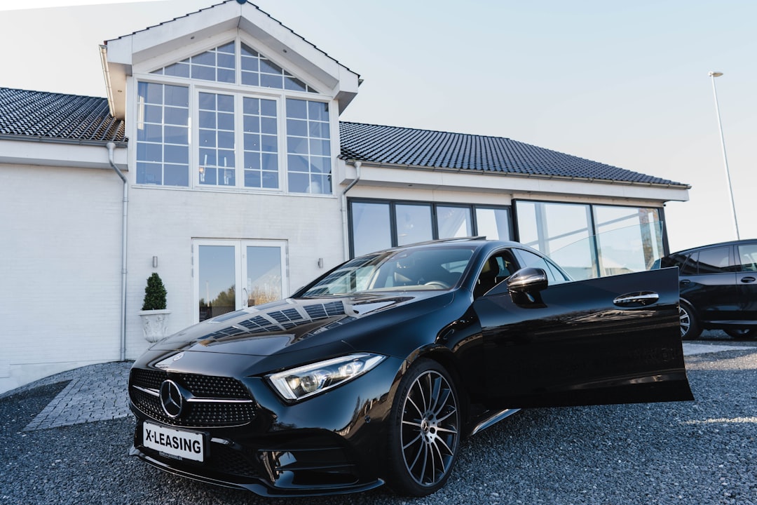 black mercedes benz coupe parked near white building during daytime