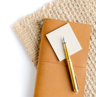gold and silver pen on brown envelope