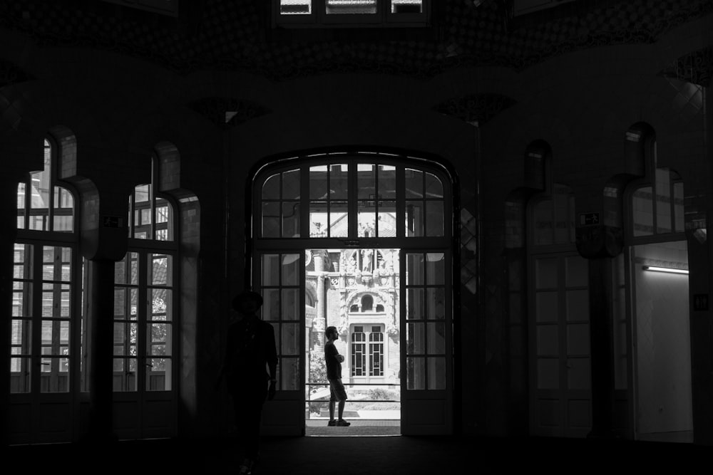 silhouette of 2 people walking on hallway