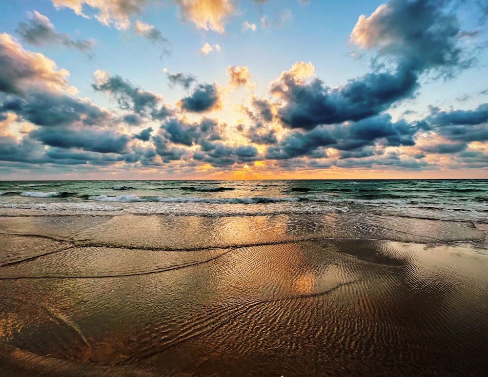 body of water under blue sky and white clouds during daytime