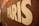 A close-up of a textured surface features the word 'PARIS' in large white letters. The background appears to be a mosaic pattern with shades of brown, red, and hints of other colors.