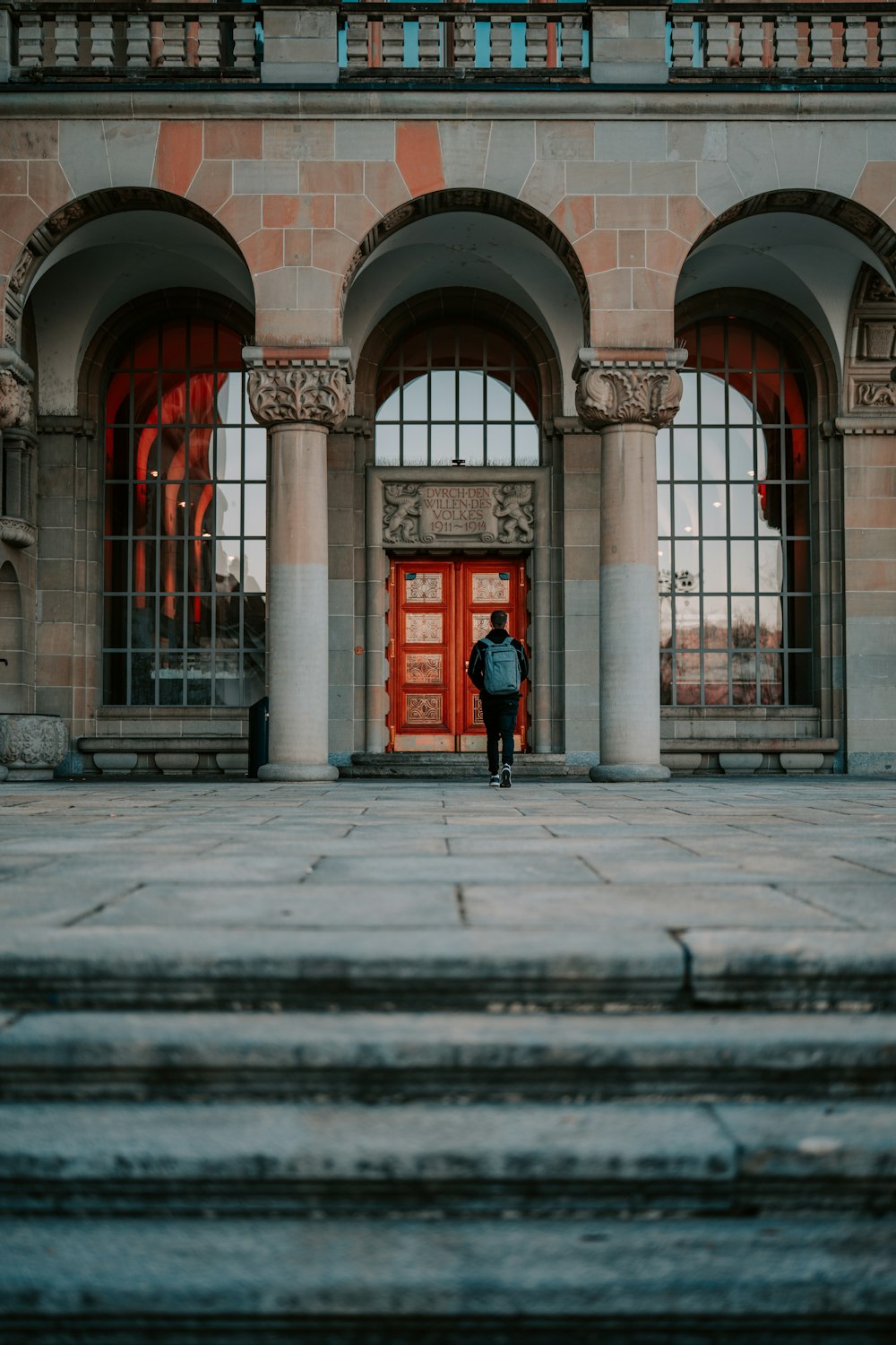 person in red jacket standing in front of building