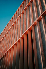 Architectural blueprint and modern building facade under soft natural light.