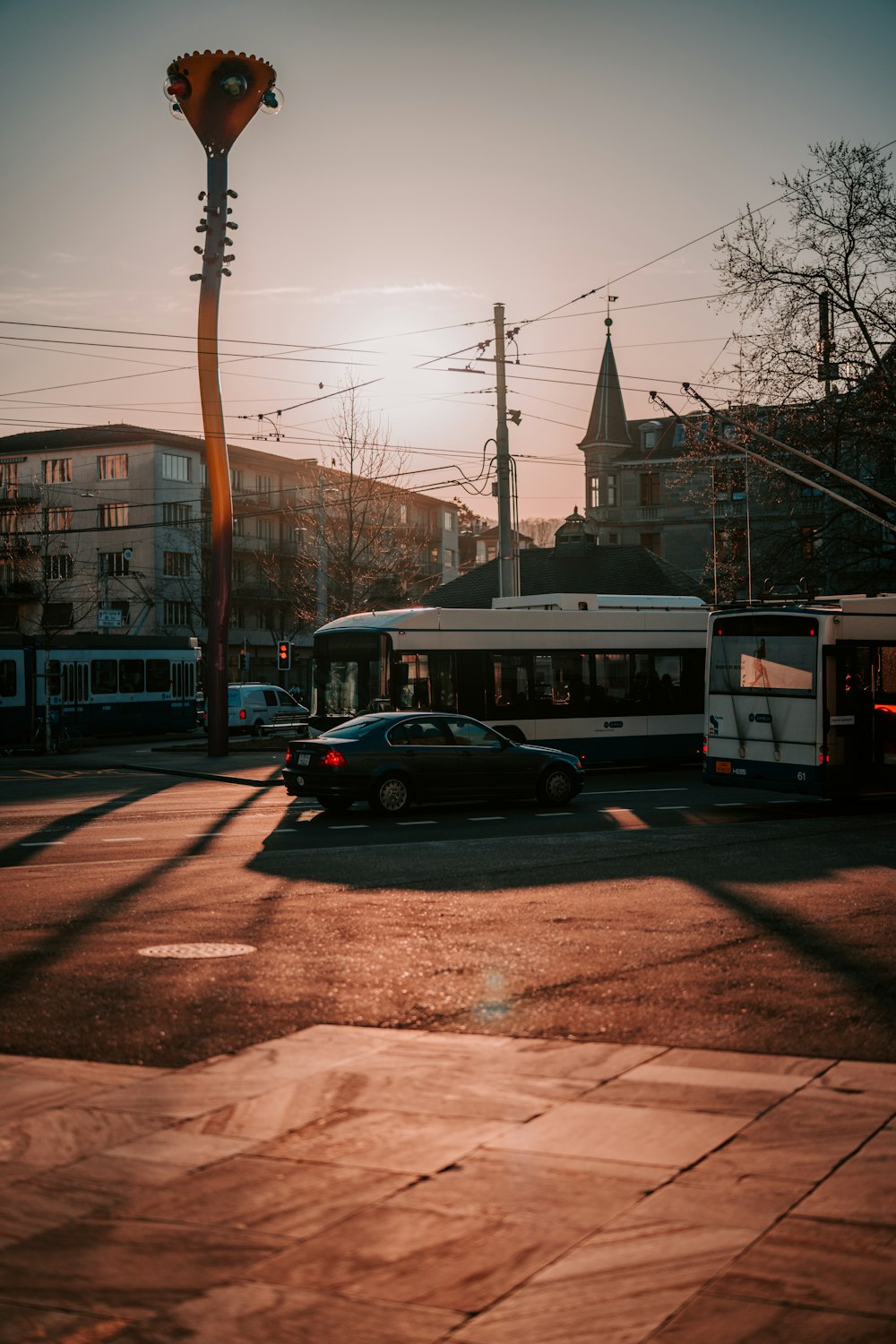 berline noire sur la route près d’un bus blanc pendant la journée