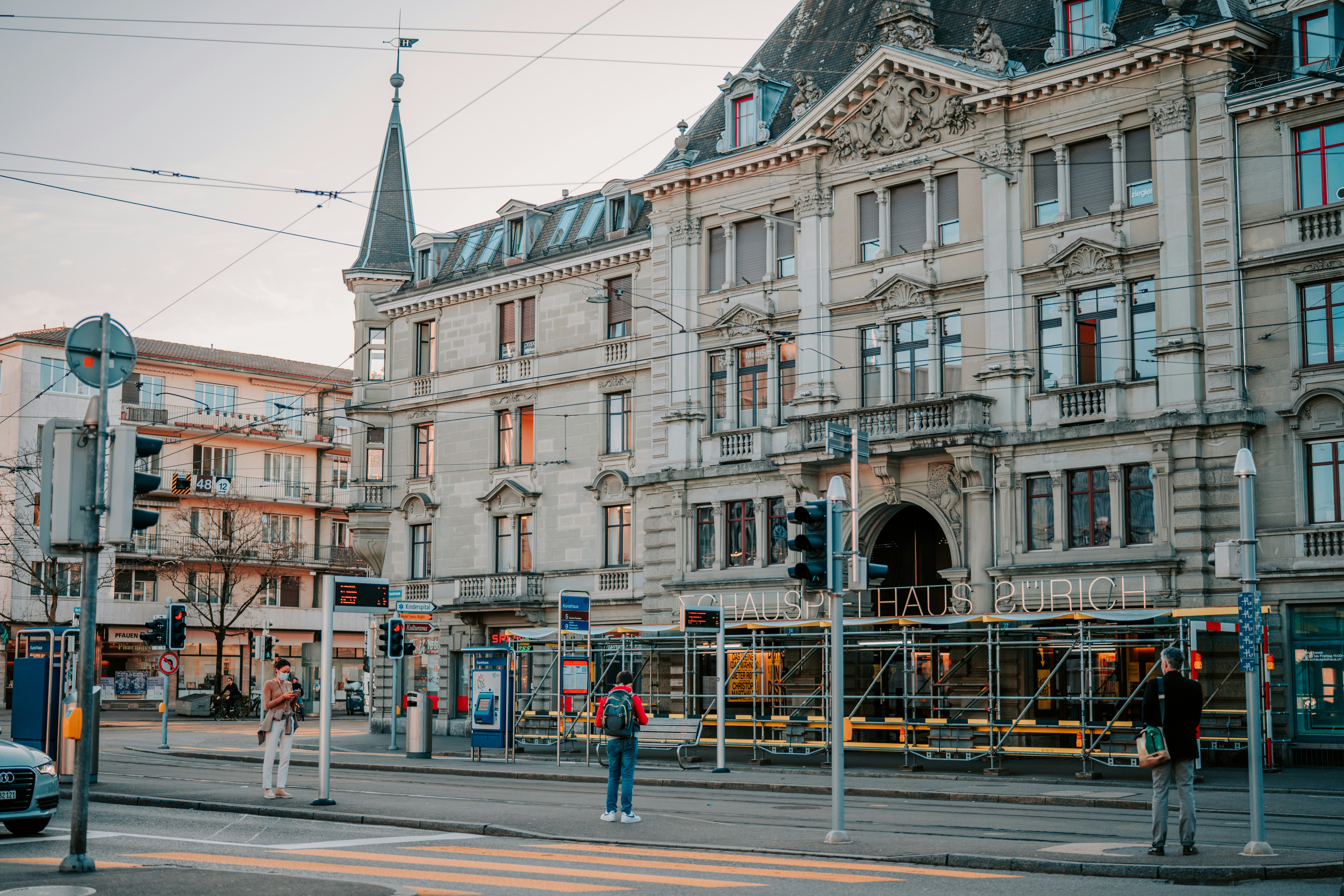 Menschen, die tagsüber auf dem Bürgersteig in der Nähe des weißen Betongebäudes spazieren gehen