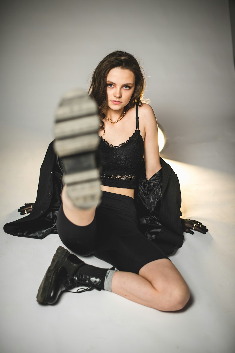 woman in black tank top and black shorts sitting on black leather armchair