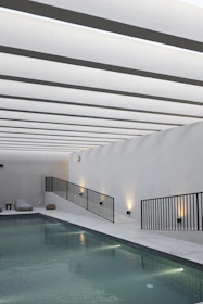 A sleek modern pool under soft natural light, showcasing minimalist design and clean lines.