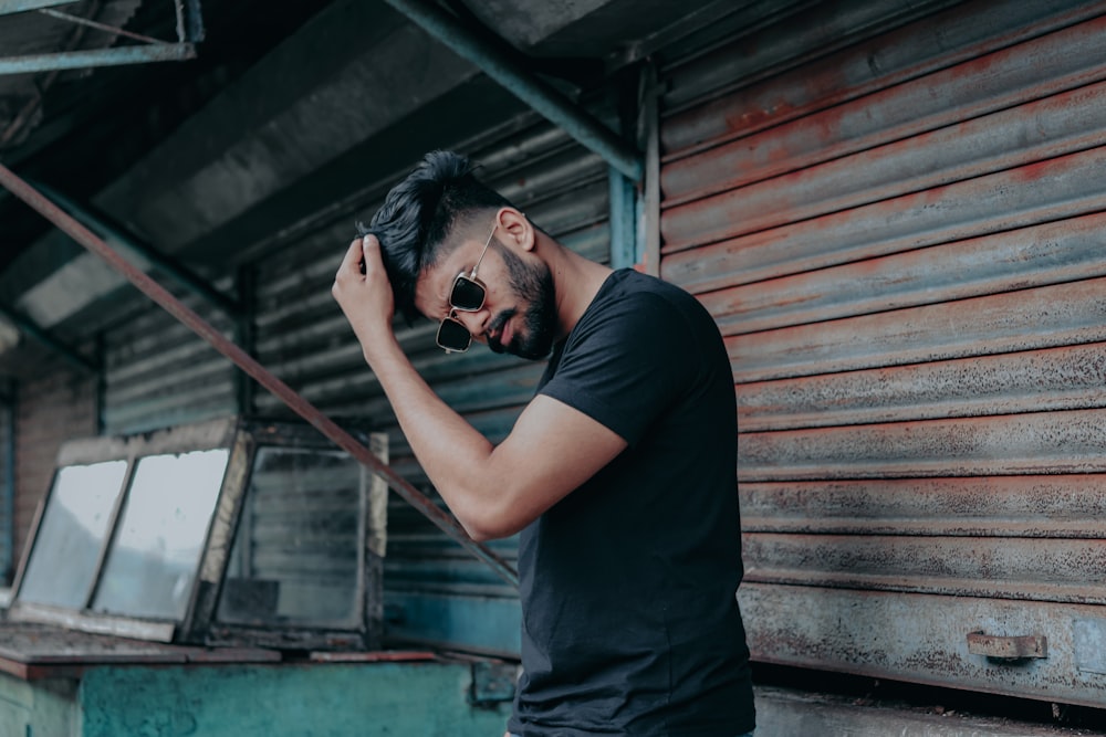 man in black t-shirt and black pants holding black dslr camera