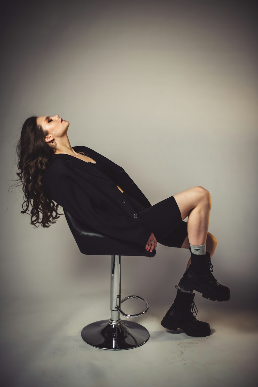 woman in black dress sitting on bar seat