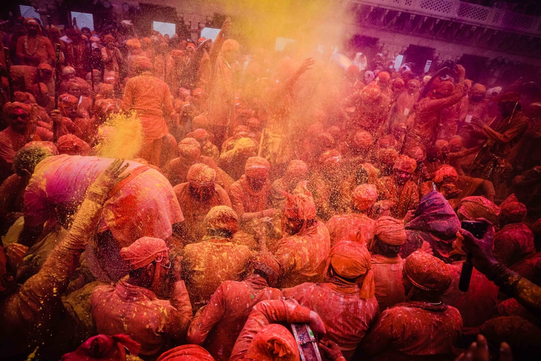 people in red and yellow long sleeve shirt dancing, holi the festival of colours