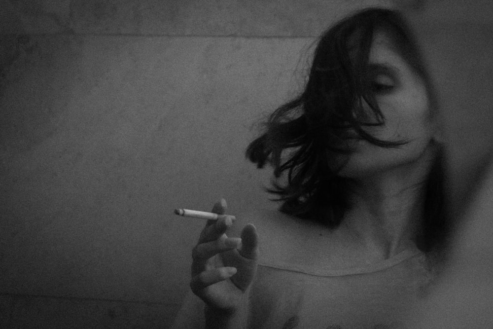 grayscale photo of woman smoking cigarette