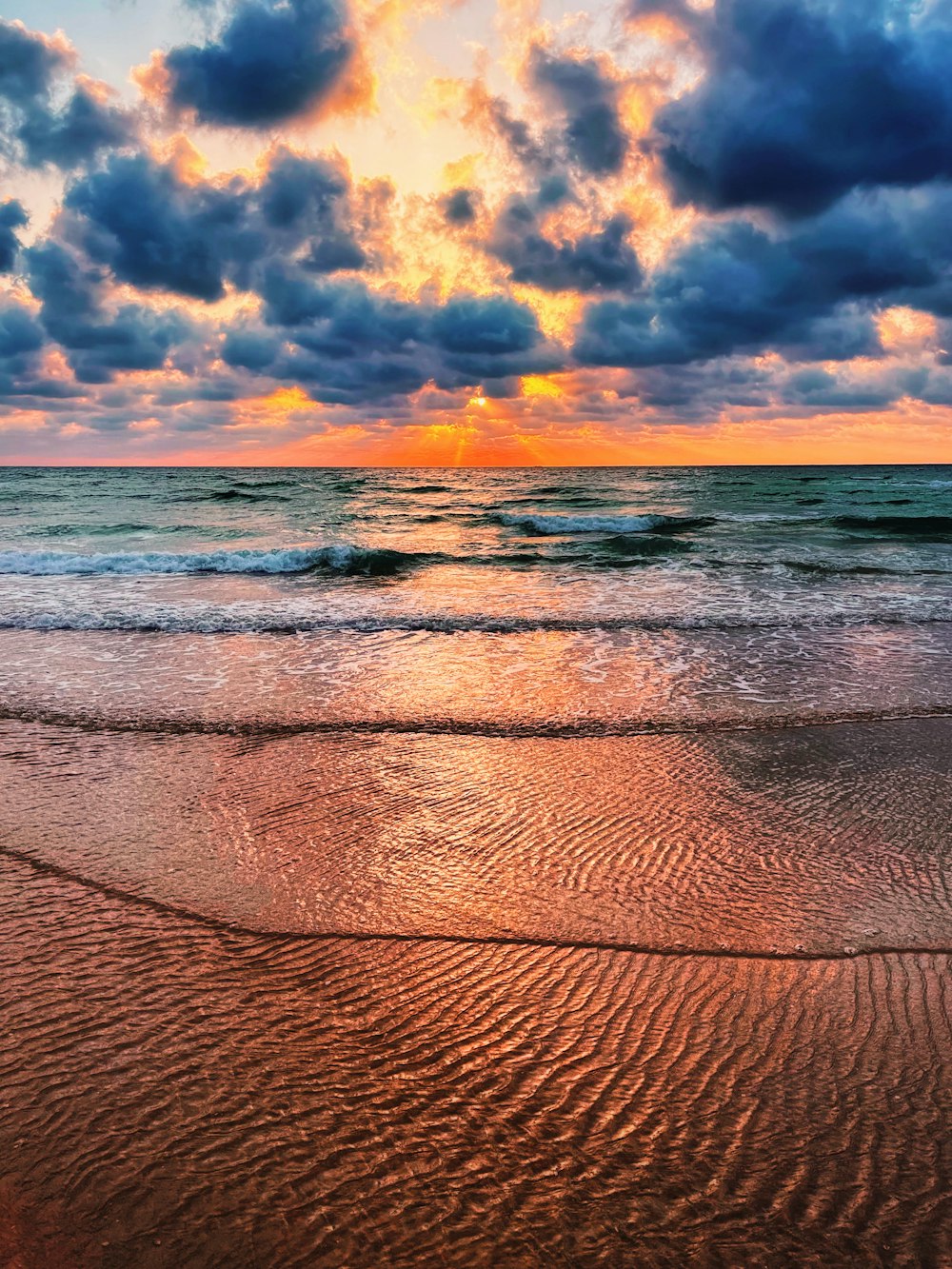 ocean waves crashing on shore during sunset