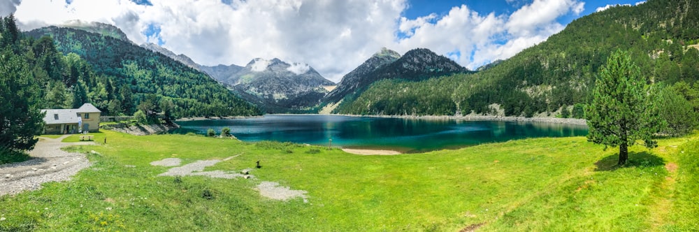 Lac au milieu d’un champ d’herbe verte et de montagnes