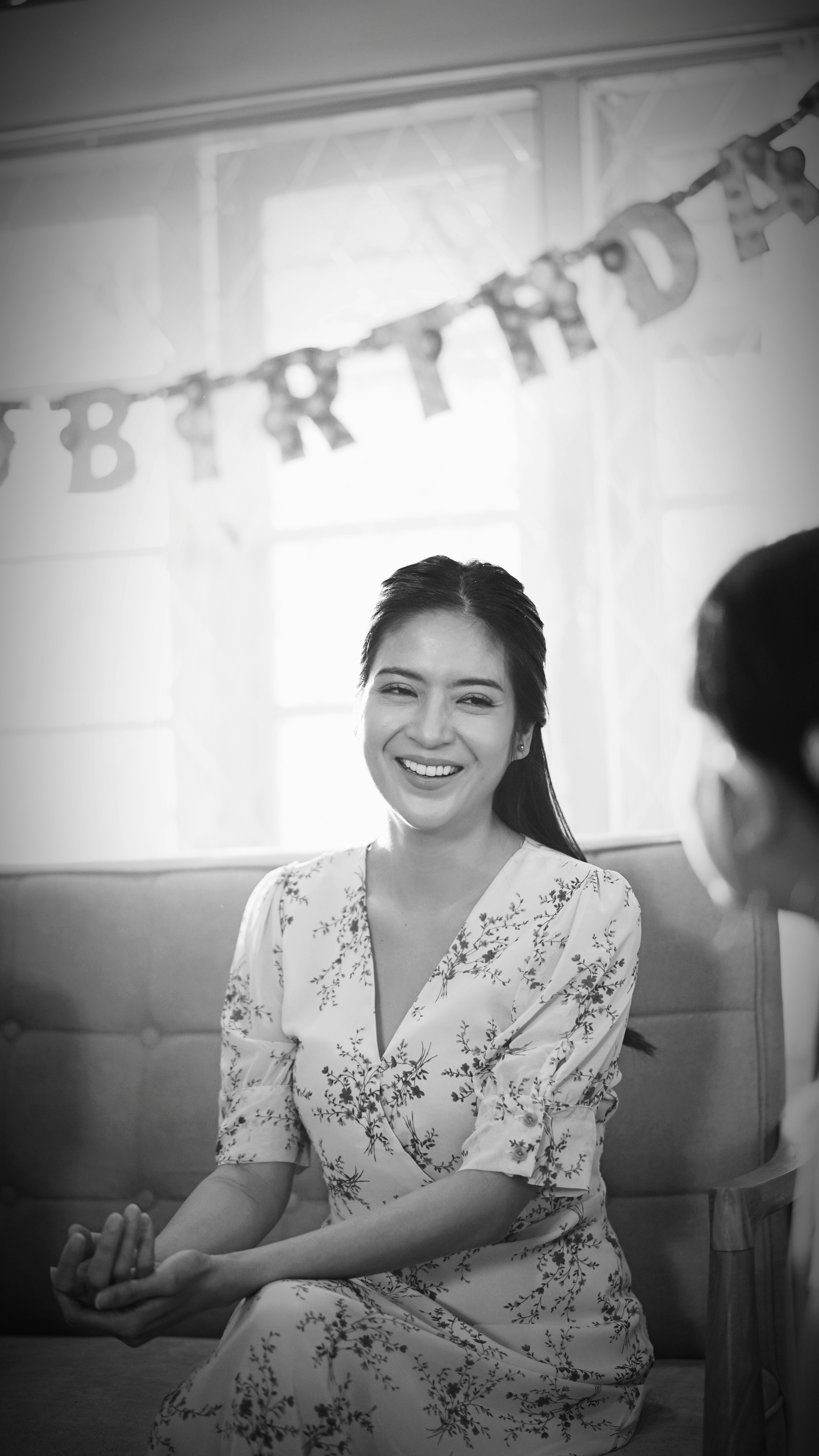 woman in white floral dress smiling