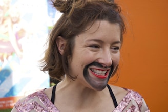 Happy customer wearing a colorful appliqué costume, smiling in natural light.