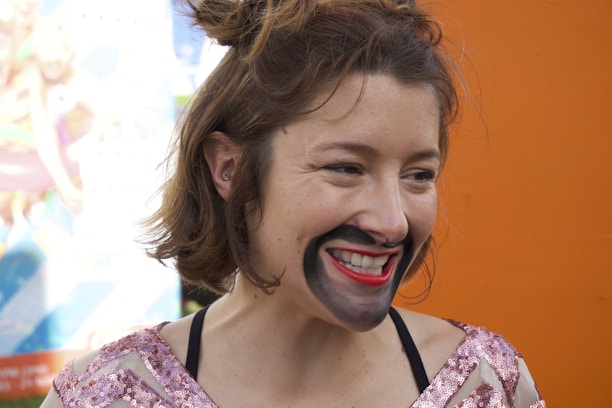 Happy customer wearing a colorful appliqué costume, smiling in natural light.