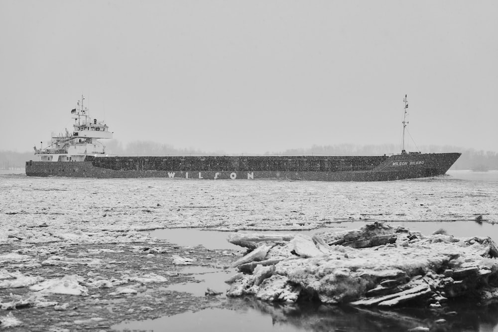 grayscale photo of rocks on water