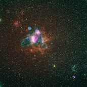 A close-up of a vibrant nebula glowing in shades of purple and pink against the dark space.