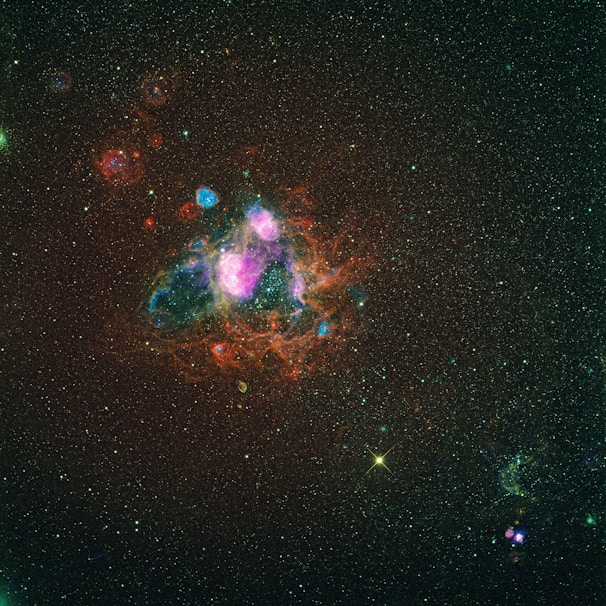 A detailed close-up of a nebula with glowing gas clouds in shades of pink and purple.
