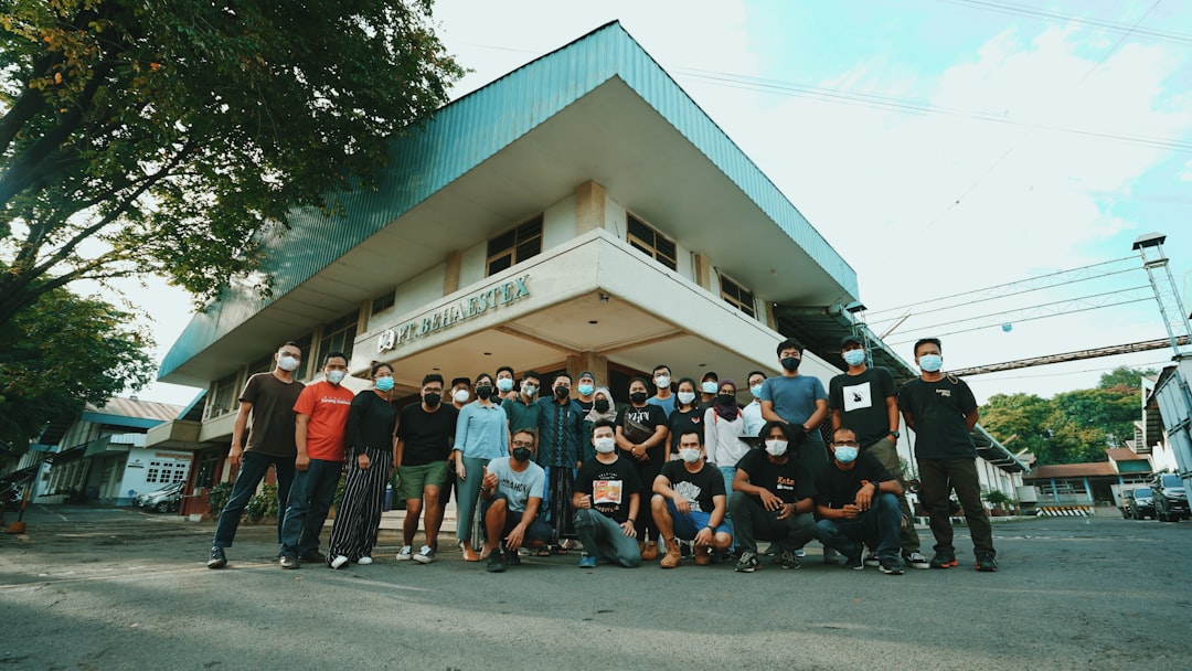 people standing in front of white and green building during daytime