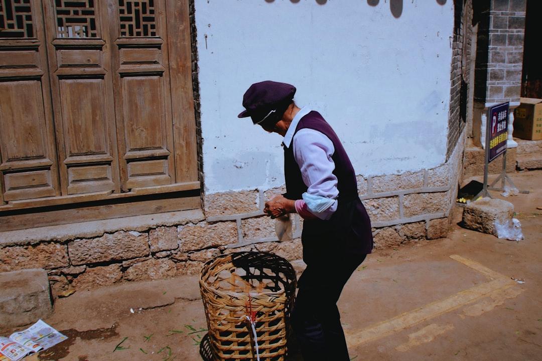 man in white and black long sleeve shirt and black pants holding brown woven basket