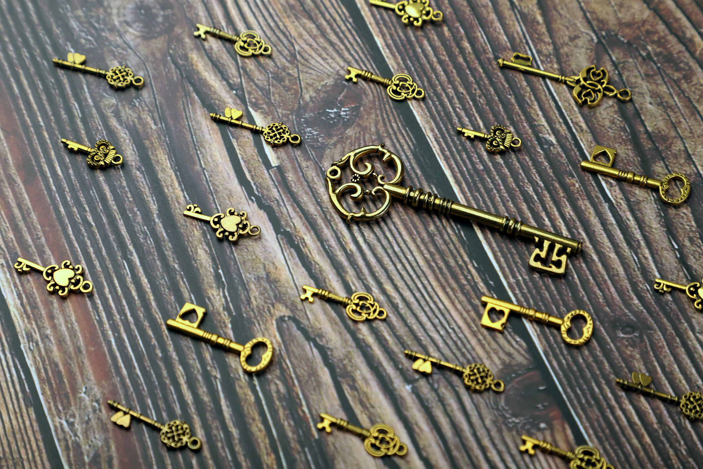 Antique brass keys scattered on dark wood