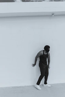 Model wearing a minimalist tech-fabric shirt standing against a dark background