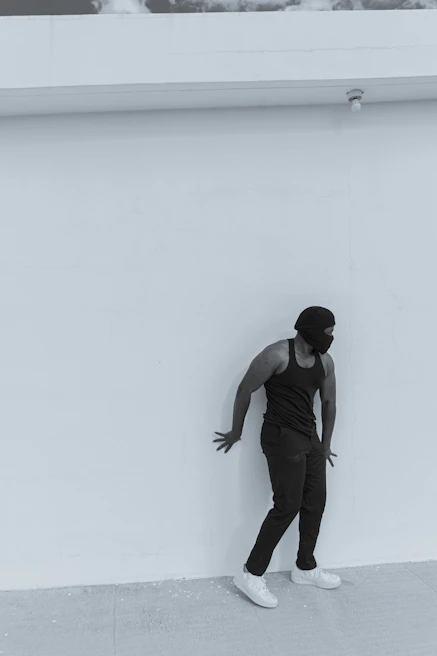 Model wearing a minimalist tech-fabric shirt standing against a dark background