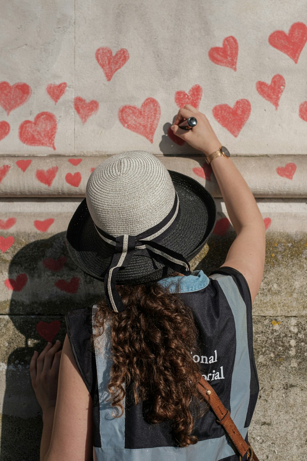 woman in black and blue shirt wearing brown hat