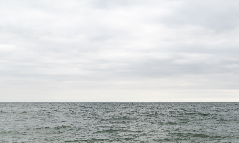 body of water under white sky during daytime