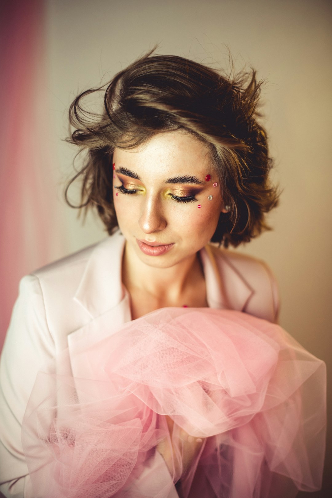 woman in white blazer holding pink textile