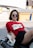 woman in red and white crew neck t-shirt and black skirt sitting on white bench