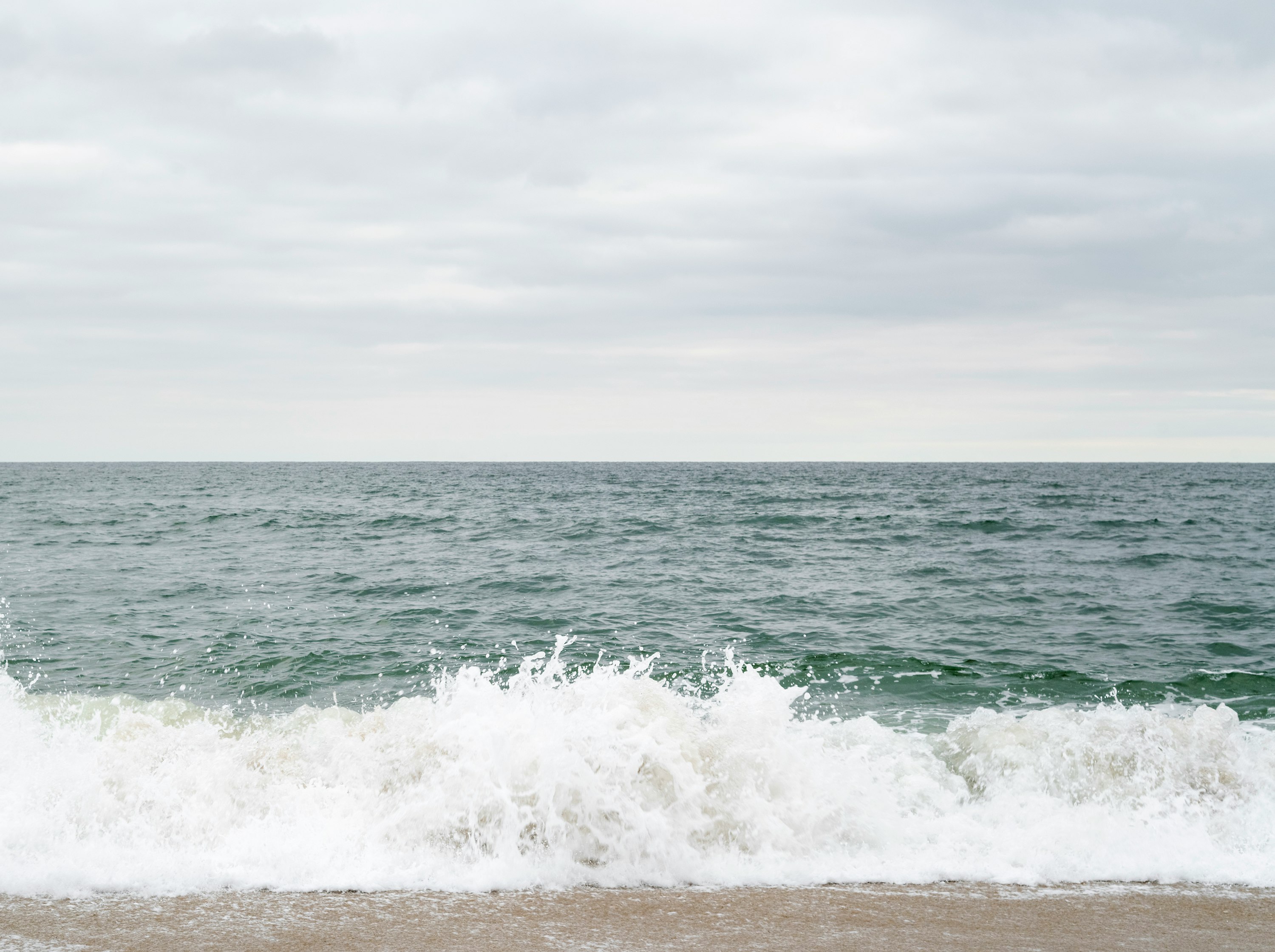 ocean waves under white sky during daytime