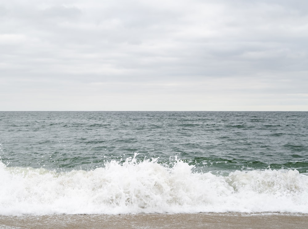 onde dell'oceano sotto il cielo bianco durante il giorno