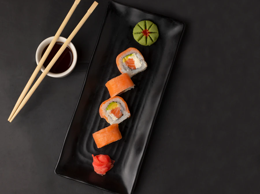 Sushi en plato negro con salsa de soya