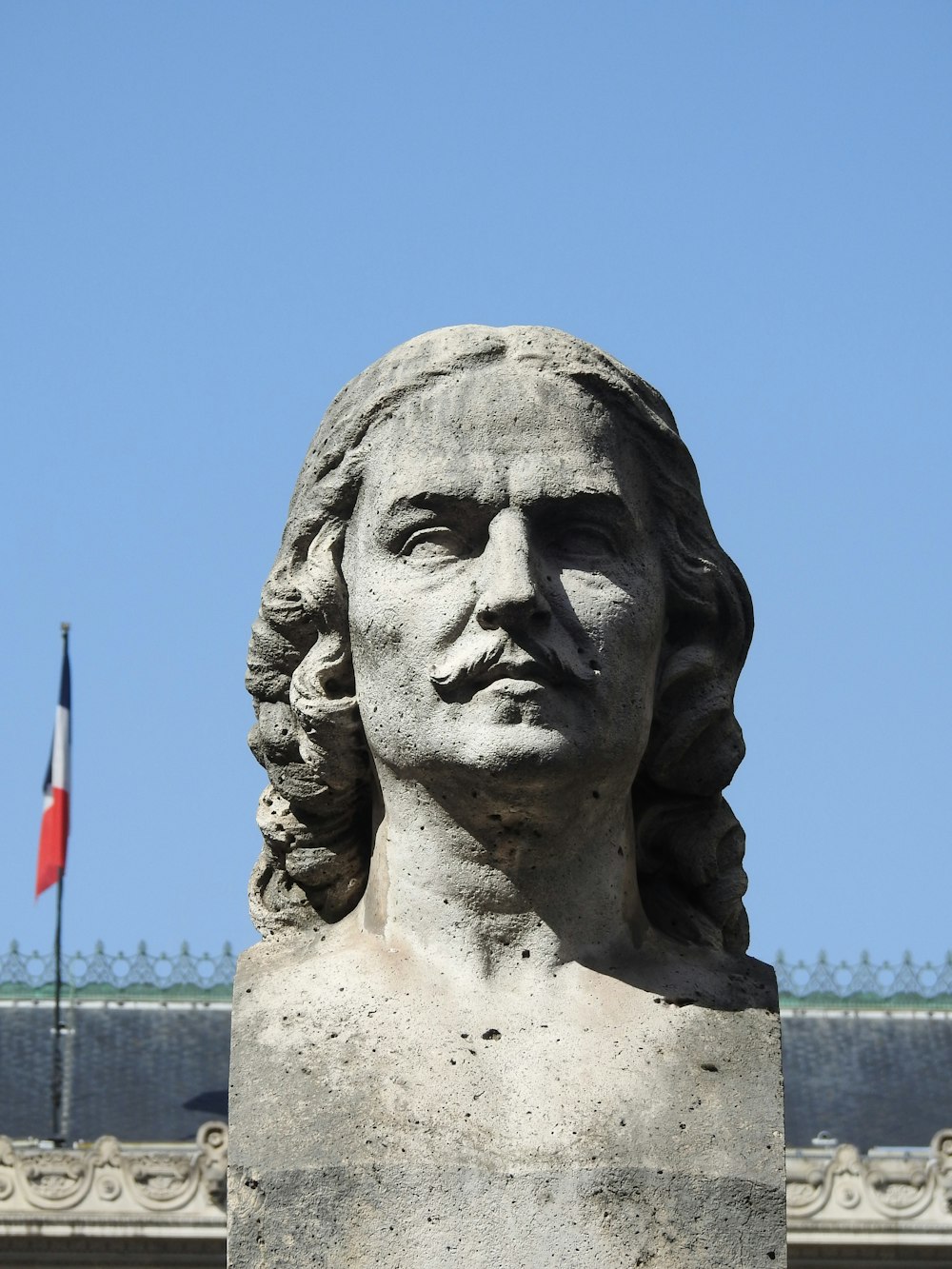 statue of man with flag on head