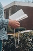 A close-up of hands holding a rosary over a devotional book titled '365 Dias de Oração'.